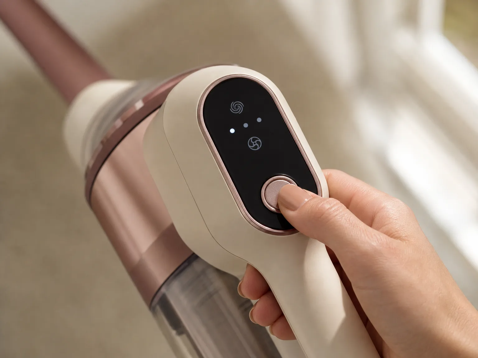 Close-up of the JRFYHFT vacuum OLED display and one-button control on the handle, showing battery level and suction mode in a warm-lit living room
