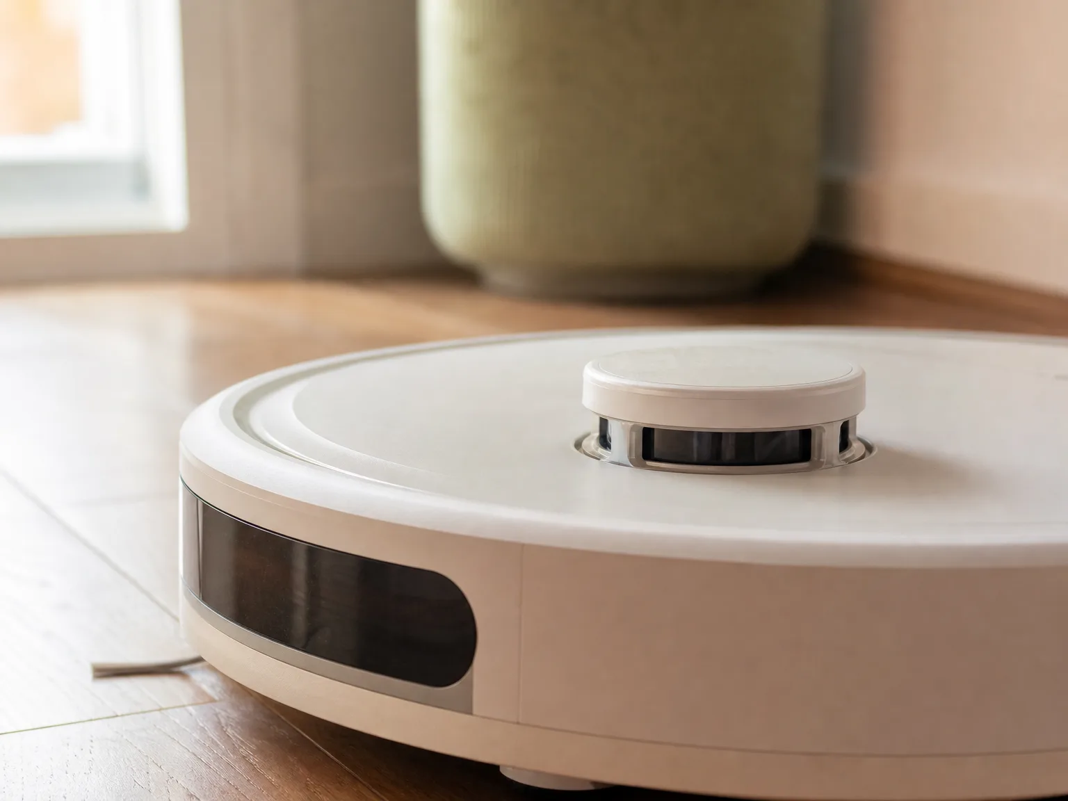 Close-up of the Roborock S5 Max lidar navigation sensor tower on a hardwood floor, warm natural light
